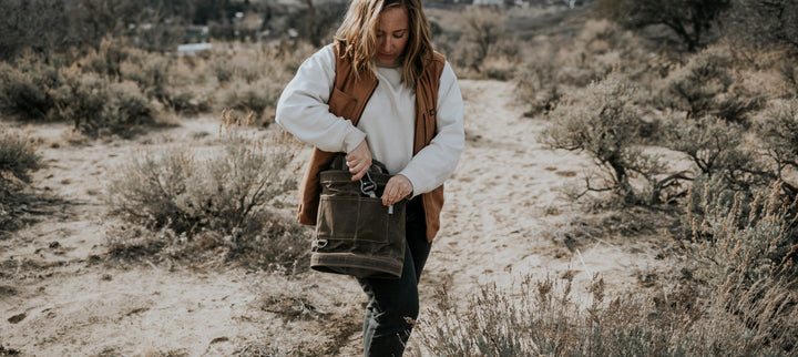 Women holding a khaki canvas bag in the mountain desert.